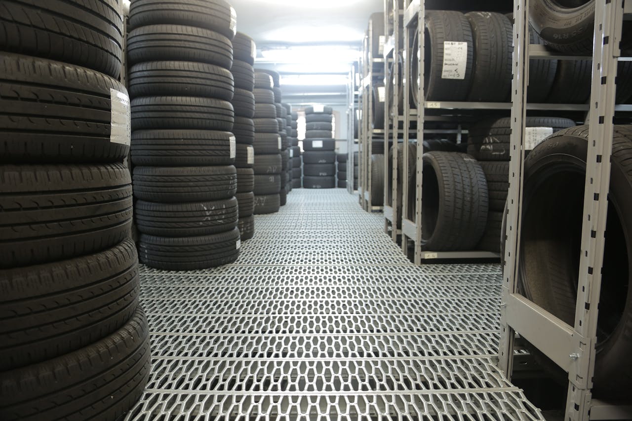 portfolio-06 Rows of stacked tires in an indoor industrial warehouse for storage.