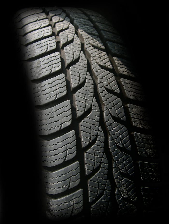 portfolio-05 Detailed close-up image of a rubber tire showcasing texture and tread pattern, ideal for design concepts.
